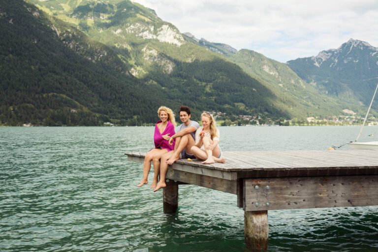 Friends sitting together on edge of pier, Innsbruck, Tirol, Austria, Europe