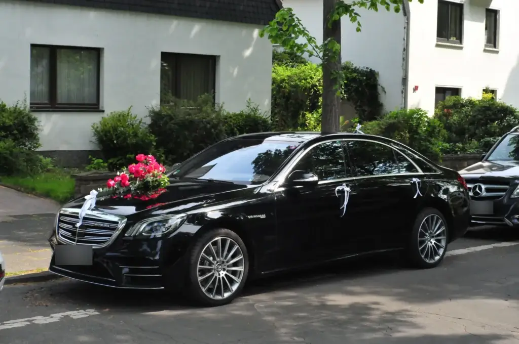 Mercedes S-Klasse als Hochzeitsauto mit roten Rosen und weißen Schleifen