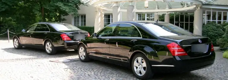 Zwei schwarze Mercedes S-Klasse vor dem Eingang eines Veranstaltungsorts